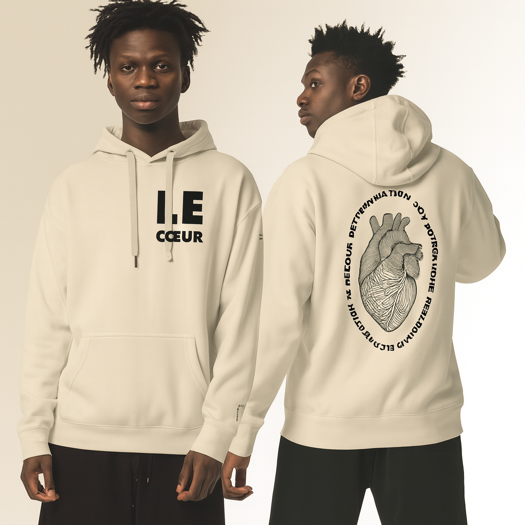 Two young men wearing cream hoodies against a neutral background; one faces forward showing bold chest text "COEUR", the other is turned away displaying a large anatomical heart illustration surrounded by circular text on the back.
