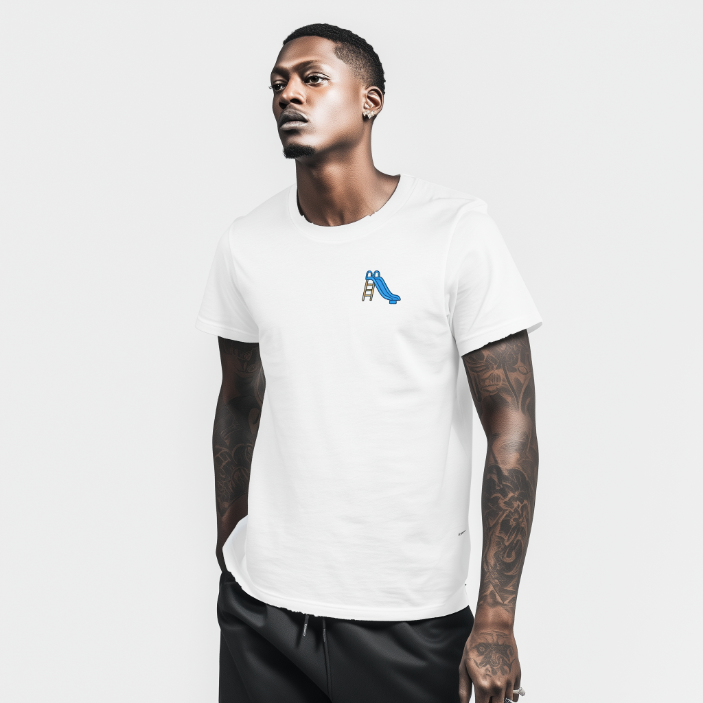Young man with short hair and an earring stands against a plain white background wearing a white t-shirt with a small blue playground slide graphic on the left chest, his tattooed forearms visible and hands in his pockets.