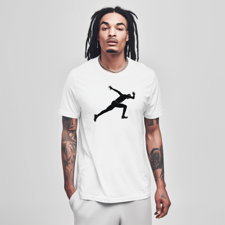 Young man with dreadlocks and tattooed arms stands against a plain light-gray background wearing a white T-shirt printed with a black silhouette of a sprinter in mid-stride, a silver chain around his neck and hands in his pockets.