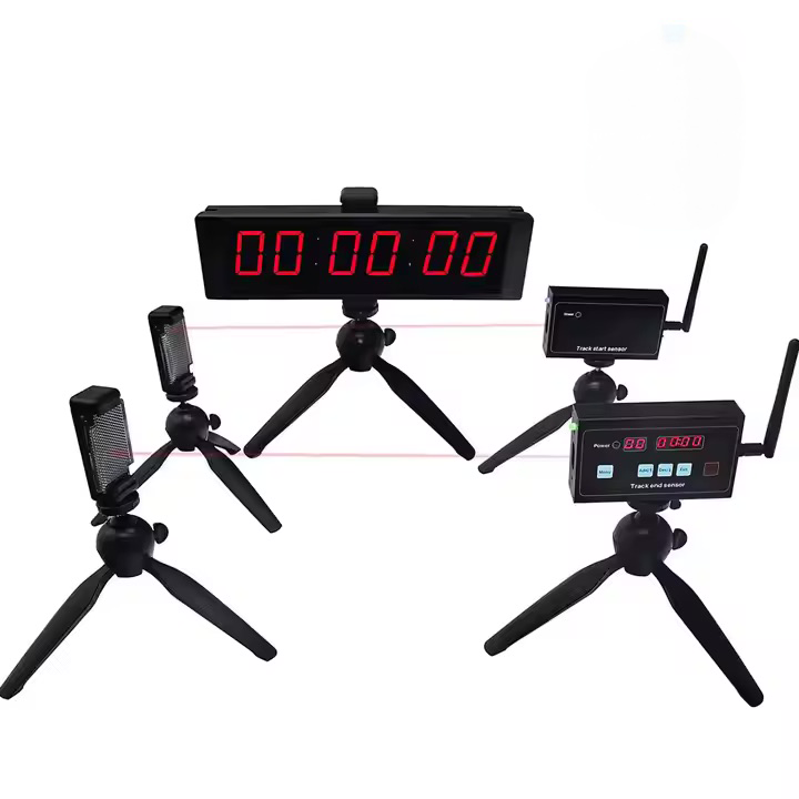Black digital race-timer kit with a central tripod-mounted LED display showing 00:00:00, two tripod-mounted laser sensor panels on the left and two tripod-mounted wireless control modules with antennas and small displays on the right connected by faint pink laser beams