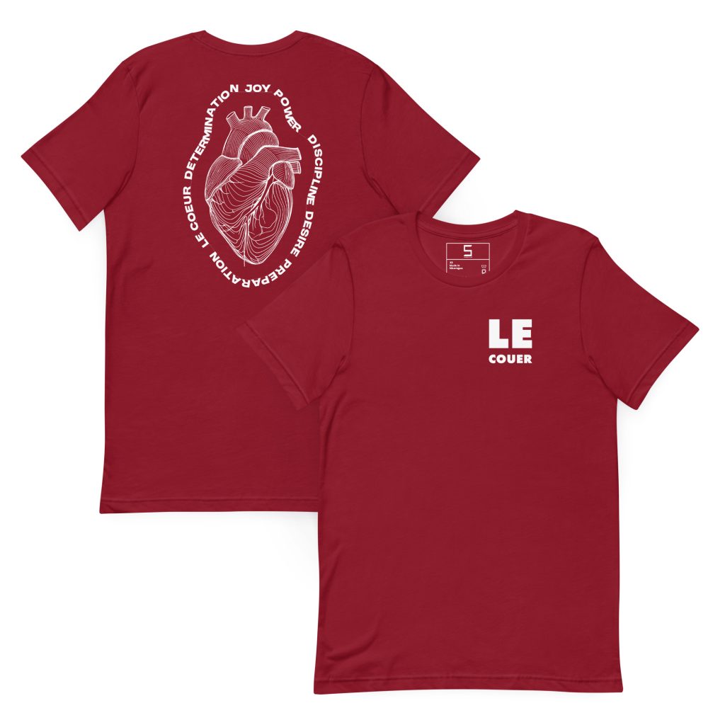 Maroon T-shirt shown front and back; front has small white block text "LE COUER" on the left chest, back displays a large white line‑art anatomical heart enclosed in an oval of white words including "joy", "power", "discipline" and "determination".